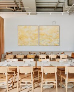space with tables combined and chairs and artwork